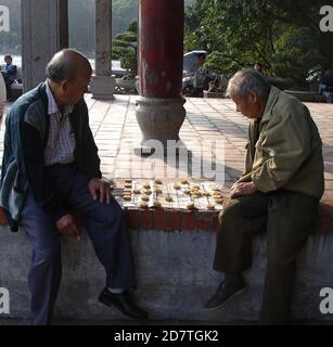 Jeu de société cờ tướn joué par des messieurs de sureau dans un parc vietnamien, Banque D'Images