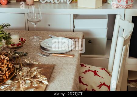 Cadre de Noël Gold place, menu de table de Noël avec carte vide, ornements et branche de pin naturel sur un manteau beige rustique, dîner à la maison Banque D'Images