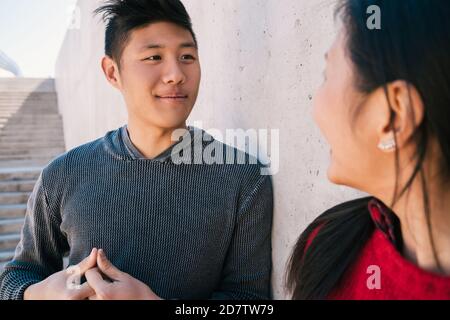 Portrait d'un charmant couple asiatique ayant une conversation tout en regardant l'un l'autre. Banque D'Images