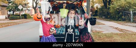 Trick ou tronc. Frère et sœurs célébrant Halloween dans le coffre de la voiture. Enfants enfants amis se préparant pour les vacances d'octobre à l'extérieur. Coffre-fort Banque D'Images