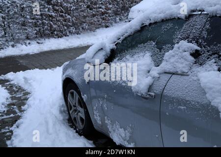 Voiture en argent garée couverte de neige blanche fraîche pendant l'hiver Banque D'Images