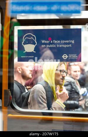 Les manifestants ont passé les instructions de la COVID-19 sur une fenêtre de bus lors d'un rassemblement anti-verrouillage à Londres, le 24 octobre 2020 Banque D'Images