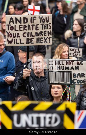 Des manifestants font des signes auprès de la foule lors d'un rassemblement anti-verrouillage à Londres, le 24 octobre 2020 Banque D'Images