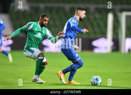 Brême, Allemagne. 25 octobre 2020. Football: Bundesliga, Werder Bremen - 1899 Hoffenheim, 5ème match. Jean-Manuel MBOM de Werder (l) combat Munas Dabbur de Hoffenheim pour le ballon. Crédit : Carmen Jaspersen/dpa - REMARQUE IMPORTANTE : Conformément aux règlements de la DFL Deutsche Fußball Liga et de la DFB Deutscher Fußball-Bund, il est interdit d'exploiter ou d'exploiter dans le stade et/ou à partir du jeu pris des photos sous forme d'images de séquences et/ou de séries de photos de type vidéo./dpa/Alay Live News Banque D'Images