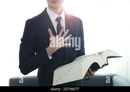 Image rognée d'un avocat tenant un livre de droit Banque D'Images