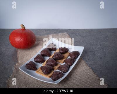 biscuits en forme de coeur de chocolat sur un fond blanc de plaque hellowen temps citrouilles Banque D'Images