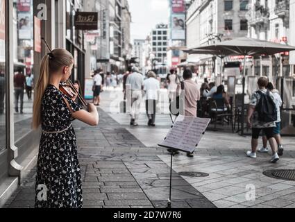 Un perfomère de rue jouant du violon pour la foule sur le trottoir, Genève, Suisse. Artiste de rue jouant du alto pour la foule, Genève, Suisse. Banque D'Images