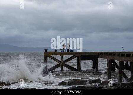 Portencross, Écosse, Royaume-Uni. 25 octobre 2020. Météo au Royaume-Uni : les gens pêchent depuis la jetée de Portencross avec l'île d'Arran en arrière-plan. Credit: SKULLY/Alay Live News Banque D'Images