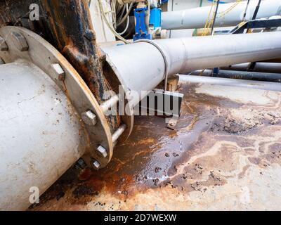 Fuite du tuyau d'eau d'égout. Fuite épaisse de déchets biologiques provenant de tuyaux en fer chromé cassés. Système d'assainissement révolutionnaire. L'eau coule sur la route depuis la rosée Banque D'Images