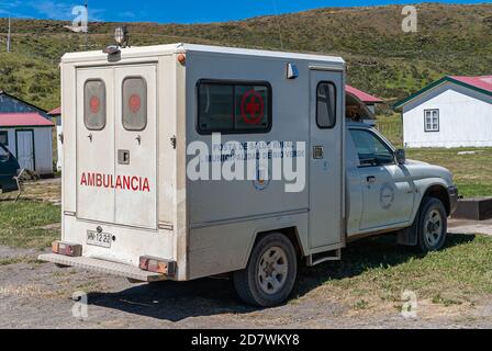 Île de Riesco, Chili - 12 décembre 2008 : minibus d'ambulance blanc avec textes bleus et rouges propriété de la commune de Rio Verde garée sur terre et herbe. Banque D'Images