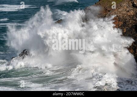 Deux pêcheurs brave d'énormes vagues sur les falaises près de Perranporth in Cornwall comme de forts vents battent le sud-ouest de la Royaume-Uni Banque D'Images