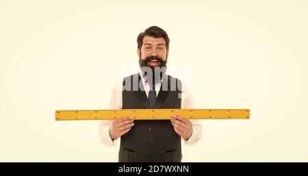 Professeur de mathématiques prenant la mesure. C'est trop grand. Homme heureux mesurer la longueur. Homme barbu avec la règle isolé sur blanc. Professeur de géométrie gai. Mathématiques pour la science. Outil pour la science mathématique. Banque D'Images