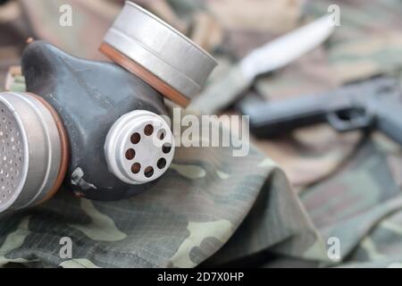 Les soldats stacker masque à gaz soviétique se trouve avec un pistolet et un couteau sur des vestes de camouflage kaki vertes. Kit post-apocalypse Surviving items Banque D'Images