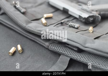 balles de 9 mm et pistolet se trouvent sur un sac à dos tactique noir. Ensemble d'éléments de service spéciaux ou d'un agent secret. Coquilles d'or dispersées autour du canon à main Banque D'Images