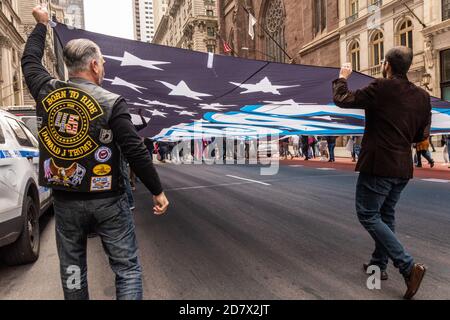 Porteur d'un drapeau « Loi et ordre » surdimensionné, les partisans de Trump défilés de la Trump Tower à Times Square à New York le 25 octobre 2020. (Photo de Gabriele Holtermann/Sipa USA) crédit: SIPA USA/Alay Live News Banque D'Images