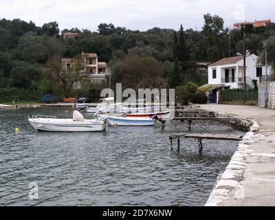 Bateaux amarrés à des jetées en bois le port traditionnel du village grec d'Agios Stefanos, Corfou, Grèce Banque D'Images