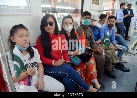 Les Pakistanais et les Chinois qui détiennent les drapeaux nationaux des deux pays et qui apprécient de voyager dans le métro ligne Orange (OLMT), alors que le ministre en chef du Punjab, M. Sardar Usman Buzdar, a inauguré le projet de métro ligne Orange à Lahore. Ce projet comprend vingt-six stations et voies s'étendant sur 27,12 km. Il s'agit du premier projet de transport public à courant électrique par lequel environ deux personnes se déplacent quotidiennement dans le lac cinquante mille.un projet de métro prévu dans le cadre du corridor économique Chine-Pakistan (CPEC), Passe sur une piste après son ouverture officielle dans la ville orientale de Lahore. (Photo par Banque D'Images