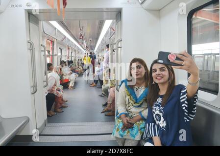 Les Pakistanais et les Chinois qui détiennent les drapeaux nationaux des deux pays et qui apprécient de voyager dans le métro ligne Orange (OLMT), alors que le ministre en chef du Punjab, M. Sardar Usman Buzdar, a inauguré le projet de métro ligne Orange à Lahore. Ce projet comprend vingt-six stations et voies s'étendant sur 27,12 km. Il s'agit du premier projet de transport public à courant électrique par lequel environ deux personnes se déplacent quotidiennement dans le lac cinquante mille.un projet de métro prévu dans le cadre du corridor économique Chine-Pakistan (CPEC), Passe sur une piste après son ouverture officielle dans la ville orientale de Lahore. (Photo par Banque D'Images