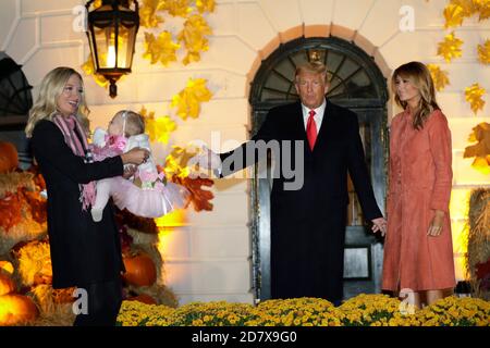 kayleigh McEnany, attachée de presse à la Maison-Blanche, qui tient sa fille de 11 mois, Blake Avery Gilmartin, est accueillie par le président américain Donald Trump et la première dame Melania Trump lors d'un événement d'Halloween sur la pelouse sud de la Maison-Blanche à Washington, DC, États-Unis, le dimanche 25 octobre 2020. Le chef de cabinet de Trump a défendu aujourd'hui la réponse de la Maison Blanche au coronavirus après l'infection d'au moins trois membres du personnel ou conseillers du vice-président Mike Pence, mais a déclaré que les États-Unis « ne vont pas contrôler » la pandémie. Crédit: Yuri Gripas/Pool via CNP | utilisation dans le monde entier Banque D'Images