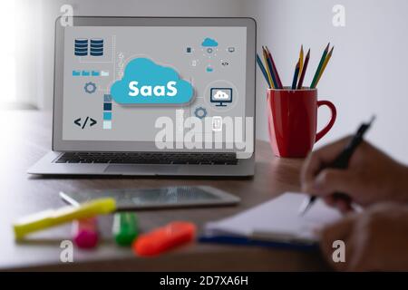 HOMME ATTENTIF AU SAAS regardant l'écran de la tablette numérique internet saas et technologie Banque D'Images