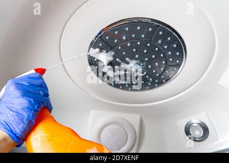 Nettoyage des cabines de vapeur de douche des dépôts de calcium. Nettoyage dans la salle de bains. Mains dans les gants avec un chiffon et détergent lave la douche et le verre Banque D'Images