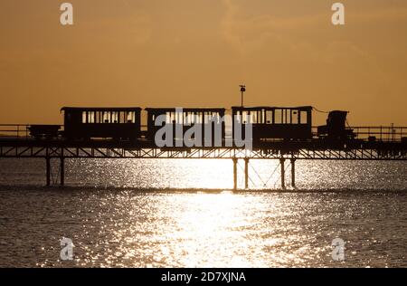 Hythe, Hampshire. 26 octobre 2020. Météo Royaume-Uni. Le soleil se lève derrière le plus ancien train sur la jetée du monde, sur Hythe Pier dans le Hampshire, lors d'une matinée froide et ensoleillée sur la côte sud. Credit Stuart Martin/Alay Live News Banque D'Images