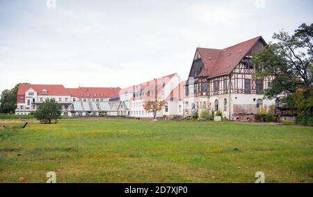 14 octobre 2020, Brandebourg, Lychen: Un bâtiment délabré et déjà rénové se dresse sur la zone du 'Parkresidenz Lychen' derrière une prairie. Les maisons du parc du Zenssee font partie des anciens sanatoriums Hohenlychen. Dans l'ancien sanatorium, 40 pour cent des maisons ont déjà été rénovées, il ya des appartements de vacances pour deux, quatre et six personnes, et 44 appartements de location sans barrière ont également été développés et la plupart d'entre eux sont déjà occupés. En raison de sa signification urbaine, historique et architecturale, le complexe est sur la liste des monuments de Brandebourg. (Vers dpa 'FR Banque D'Images