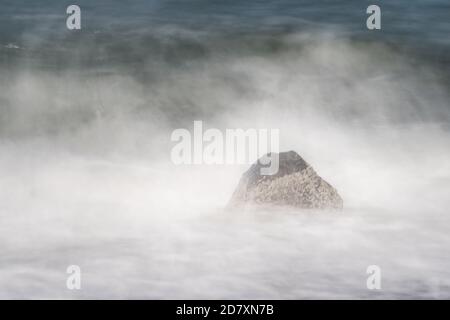 Faites du surf avec des vagues qui se brisent tout autour. Vitesse d'obturation lente créant une atmosphère de rêve et de brume. Côte de la mer du Nord, Westkapelle, pays-Bas Banque D'Images