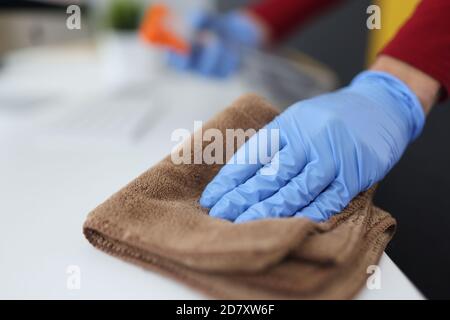 Main gantée pour tenir le chiffon en microfibre et la table de lingettes. Banque D'Images