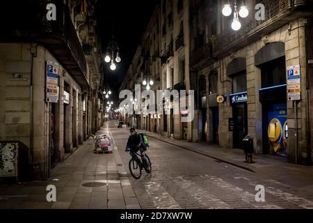 Barcelone, Espagne. 25 octobre 2020. 25 octobre 2020, Barcelone, Catalogne, Espagne: Un cycliste traverse une rue solitaire de Barcelone pendant la première nuit du couvre-feu. Le Premier ministre espagnol a approuvé aujourd'hui un nouvel état d'urgence avec des plans pour le maintenir en place jusqu'en mai et le gouvernement catalan impose un couvre-feu obligatoire entre 22h et 6h du matin. Credit: Jordi Boixareu/Alamy Live News Banque D'Images