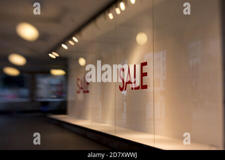 vente écrite en lettres rouges sur le volet d'une fenêtre de magasin vide Banque D'Images