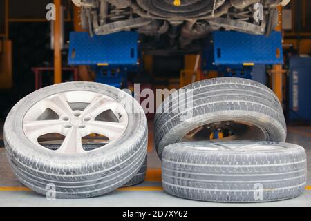 Les roues de la voiture sont sur le plancher dans le garage, vieux pneu de voiture dans le garage changement et réparation concept Banque D'Images