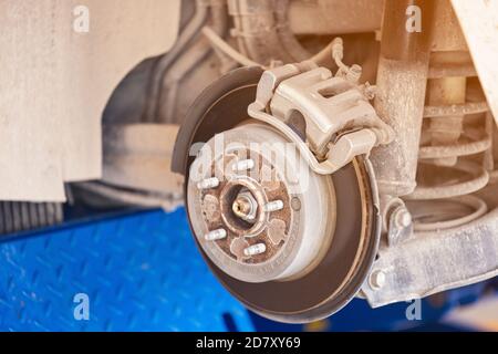 Gros plan pièce de frein de voiture au garage, rupture de vidage arrière ancienne et sale du véhicule pour réparation suspension dans l'entretien de voiture. Banque D'Images