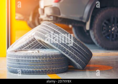 Les roues de la voiture sont sur le plancher dans le garage, vieux pneu de voiture dans le garage changement et réparation concept Banque D'Images