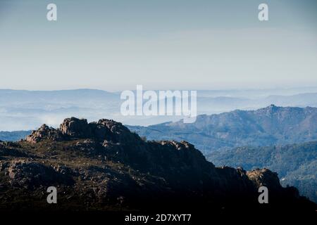 Les formes et les courbes des montagnes disparaissent à l'horizon sous le brouillard du matin Banque D'Images