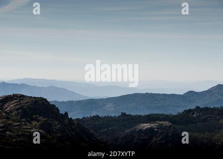 Les formes et les courbes des montagnes disparaissent à l'horizon sous le brouillard du matin Banque D'Images