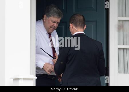 Le procureur général des États-Unis, William Barr, parle avec un membre de ses détails protecteurs après son arrivée à son domicile le jeudi 18 avril 2019 à McLain, en Virginie, aux États-Unis. Barr a publié aujourd'hui une version biffée du rapport final du conseiller spécial Robert Mueller, et ce document pourrait rendre tout le monde insatisfait, le président Donald Trump, les législateurs et le public. Crédit : Alex Edelman/l'accès photo Banque D'Images