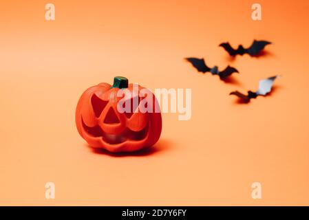 Chauves-souris artificielles et citrouille sur fond orange. Joyeux Halloween concept de vacances. Flat lay, vue de dessus, espace de copie. Banque D'Images