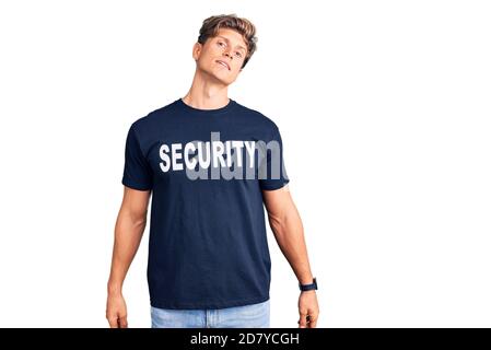 Jeune homme beau portant une chemise de sécurité qui a l'air endormi et fatigué, épuisé pour la fatigue et la gueule de bois, les yeux paresseux le matin. Banque D'Images