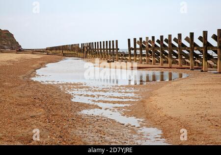 Vue sur les défenses de la mer qui ont fait dérailler sur la côte nord de Norfolk à Happisburgh, Norfolk, Angleterre, Royaume-Uni. Banque D'Images