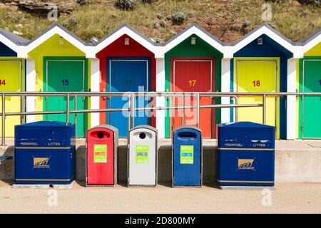 Huttes de plage colorées et bacs de recyclage, Barry Island, Glamourgan, pays de Galles du Sud. Banque D'Images