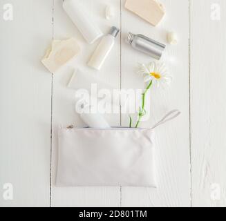 Placez les produits cosmétiques blancs sur une table en bois avec des fleurs dans un sac à cosmétiques. Beauté soins de la peau traitement des cheveux cosmétique sérum huile hydratant crème pour la peau Banque D'Images