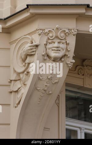 Mascaron drôle avec les mains sur le corbel de la baie vitrée d'angle de la maison de revenu Art Nouveau à Prague, République Tchèque. Le bâtiment Art nouveau conçu par l'architecte tchèque Osvald Polívka et décoré de stuc par le sculpteur tchèque Antonín Popp a été construit en 1903 à l'angle des rues Vojtěšská et Na Struze à Nové Město (Nouvelle ville). Banque D'Images