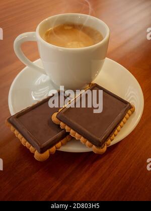 Café expresso dans une tasse blanche et biscuits au beurre recouverts de chocolat noir. Espace de copie disponible Banque D'Images