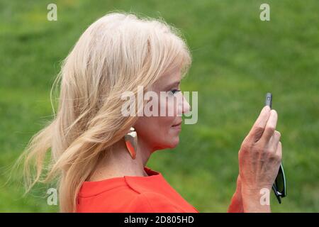 Kellyanne Conway, conseillère de la présidente, prend une photo par téléphone tandis que le président américain Donald Trump s'adresse aux médias avant d'embarquer à bord de Marine One sur la pelouse sud de la Maison Blanche à Washington, D.C., aux États-Unis, le mercredi 24 juillet 2019. Trump se rendra en Virginie-Occidentale pour une levée de fonds avant de revenir à la Maison Blanche ce soir. Crédit : Alex Edelman/l'accès photo Banque D'Images