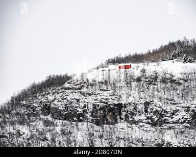 Maison solitaire rouge sur la montagne en hiver à Framfjorden, Norvège. Banque D'Images