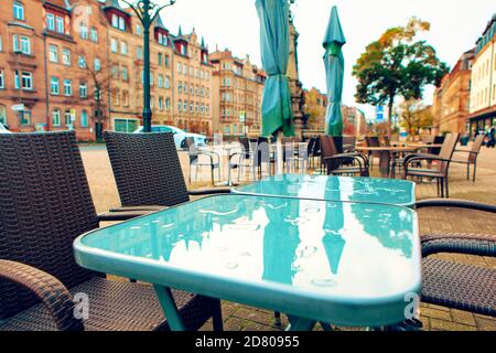 Terrasse de rue après la pluie . Réflexion sur la ville dans une table de café Banque D'Images