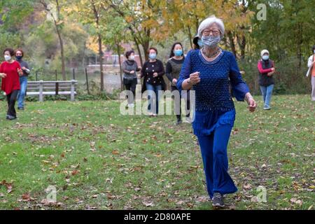 Un groupe de femmes asiatiques américaines de tous âges portent des masques et des distances sociales. Lors d'un cours d'exercice de danse dans un parc de Flushing, Queens, New York. Banque D'Images