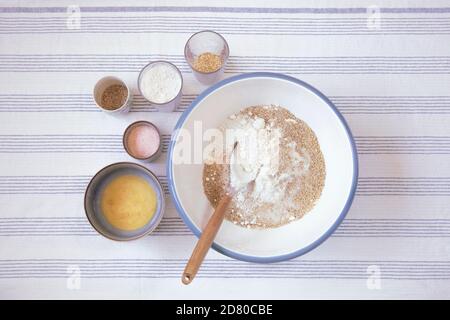 Préparation de la pâte pour le pain dans la cuisine. Bol avec farine et ingrédients pour la recette sur le côté, plat. Cuisson à la maison. Banque D'Images