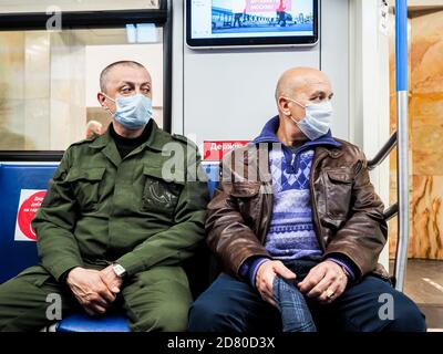 Moscou. Russie. 13 octobre 2020. Deux hommes sont assis sur un siège dans une voiture de métro. Sur le visage des passagers sont des masques de protection. Inscriptions dans Banque D'Images